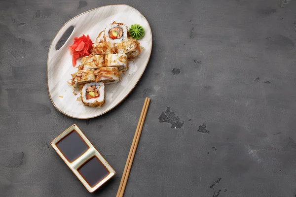 Draufsicht auf Sushi-Rolle mit Thunfischspänen auf Teller — Stockfoto