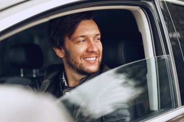 Arabada oturan kendinden emin genç adam.