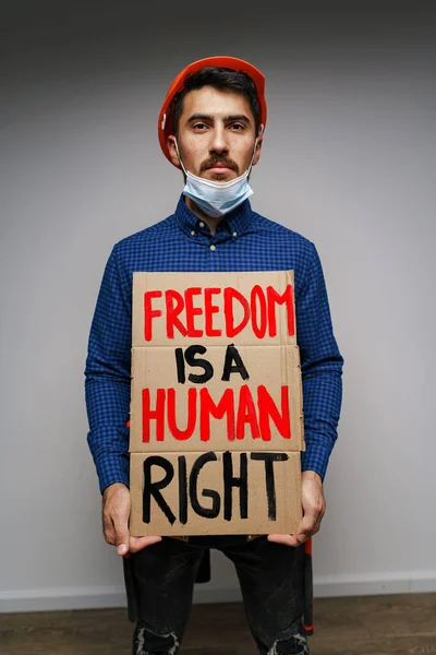 La libertà è un cartello dei diritti umani nelle mani dell'uomo manifestante — Foto Stock