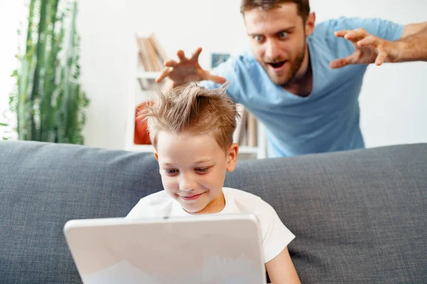 Papá asusta a su pequeño hijo que usa tableta digital — Foto de Stock