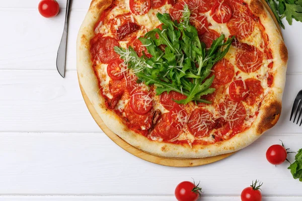 Pepperoni Pizza an Bord auf weißem Holztisch — Stockfoto