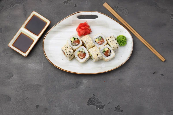 Horní pohled na sushi roll se sezamem na tmavě šedém pozadí — Stock fotografie