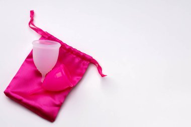 Beyaz arka planda pembe çantalı iki adet bardağı.