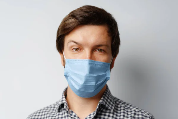 Man bär hygienisk mask mot grå bakgrund — Stockfoto