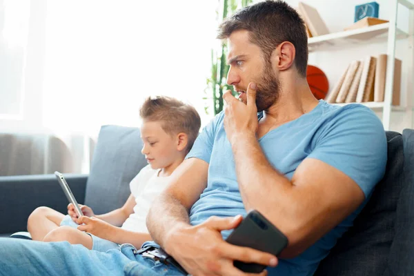 Padre preocupado mirando lo que su hijo está viendo en la tableta digital — Foto de Stock