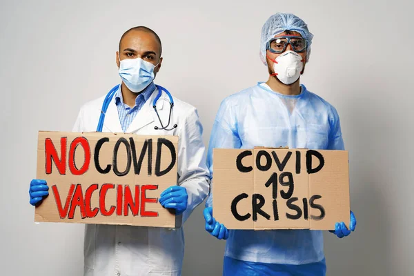 People in medical gowns wearing face masks protesting and holding placards — Stock Photo, Image