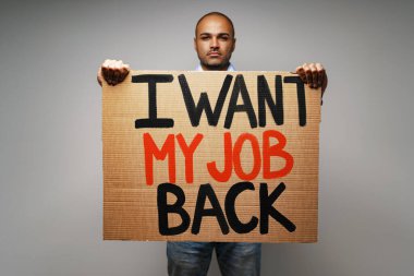 Pankart. İşimi geri istiyorum. Maskeli bir protestocunun ellerine. .