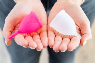 Adet bardağını elinde tutan kadın. Yakından.