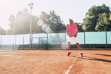Açık havada tenis oynayan orta yaşlı bir adam dosyalanmış.