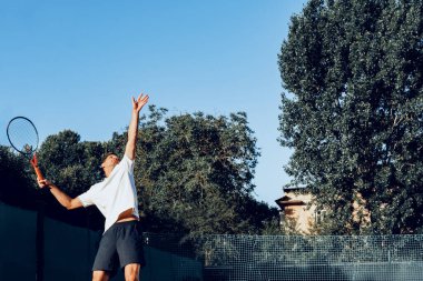 Genç proffesional tenis oyuncusu servis yapıyor.