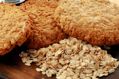 Tahta yüzeyde yulaf kurabiyeleri ve yulaf ezmesi.