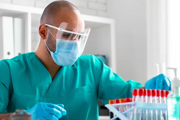 Un médecin afro-américain ou un travailleur de laboratoire examine un échantillon de sang en clinique — Photo