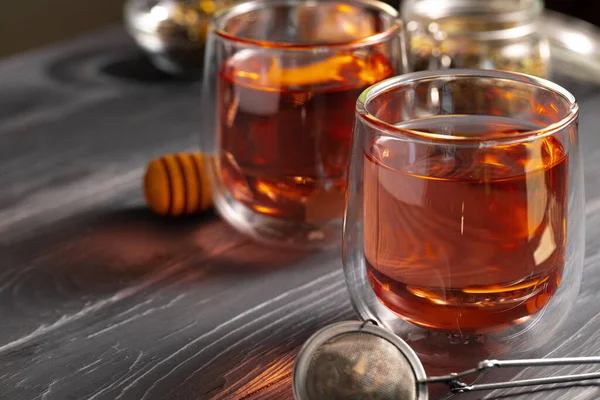 Théière en verre et tasses en verre de thé aux fruits sur fond en bois — Photo