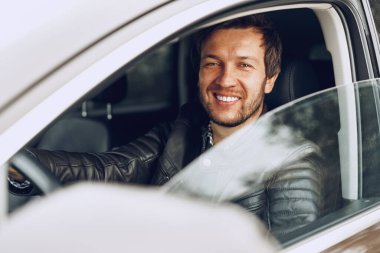 Arabada oturan kendinden emin genç adam.