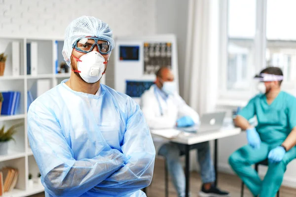 Hastane dolabında koruyucu önlüklü bir erkek doktor duruyor. — Stok fotoğraf
