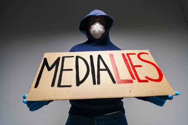 Media bugie dipinte su cartello nelle mani di manifestante uomo — Foto Stock