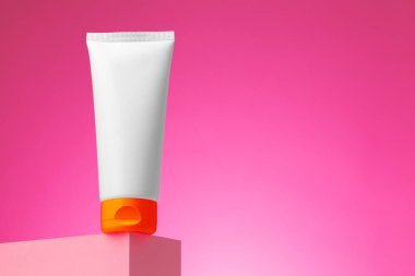 Pembe arka planda boş beyaz kozmetik kabı