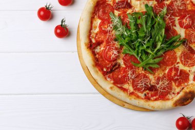 Biberli pizza beyaz ahşap masada.