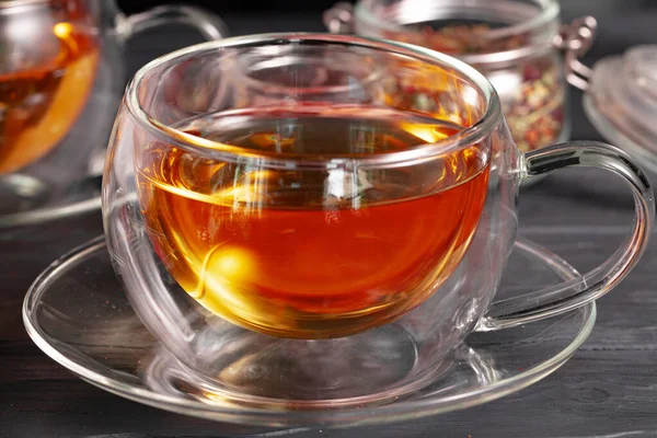 Стеклянная чашка чая и чайник на столе — стоковое фото