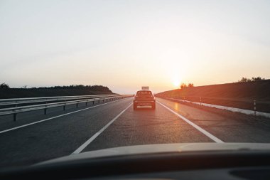 Şafakta otoyolda giden yolcu vagonu.