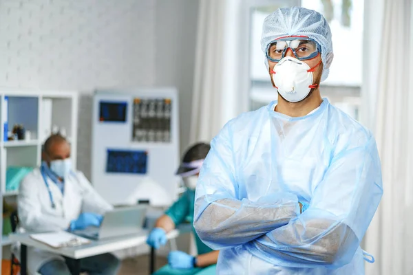 Médico masculino em vestido médico de proteção em pé no armário do hospital — Fotografia de Stock