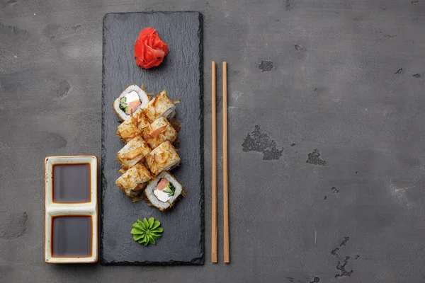 Draufsicht auf Sushi-Rolle mit Thunfischspänen auf Teller — Stockfoto
