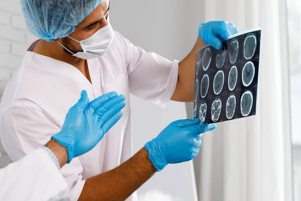 Erkek doktor hastanın MRI beyin taramasını inceliyor. — Stok fotoğraf
