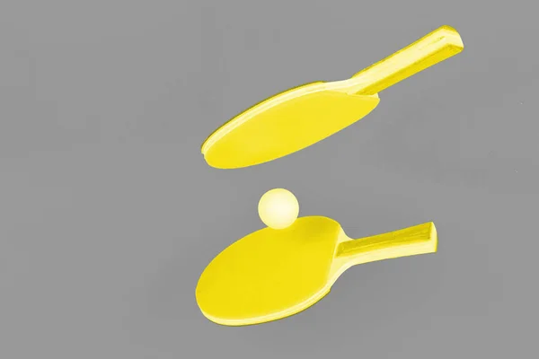 Просветительные желтые ракетки для пинг-понга на фоне Ultimate Gray — стоковое фото