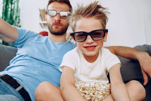 Pai e filho assistindo filmes em casa em óculos 3d e comer pipocas — Fotografia de Stock