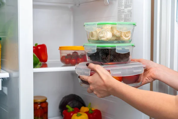 냉장고에서 음식을 담아 가는 여성 손 — 스톡 사진