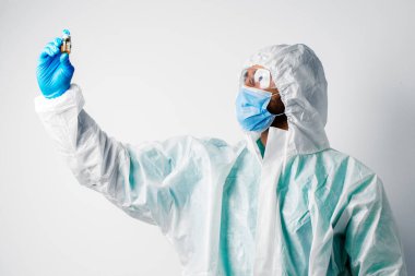 Doktor ya da hemşire koruyucu giysiler içinde aşıya hazırlanıyor.