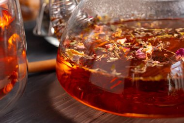 Arka planda meyve çayı olan cam çaydanlık.