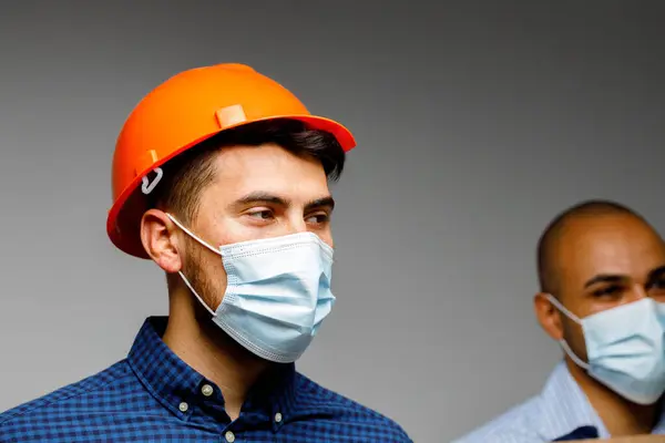 Obrero de la construcción con máscara protectora retrato sobre fondo gris —  Fotos de Stock