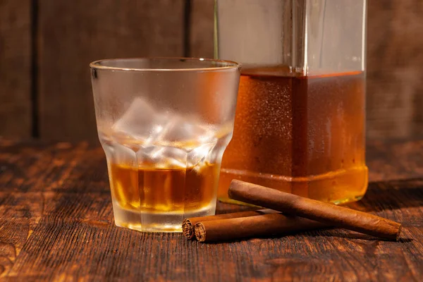 Un verre de whisky et un cigare sur une table en bois — Photo