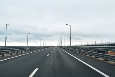 Asfalt yolu ve bulutlu gökyüzü ile boş otoyol