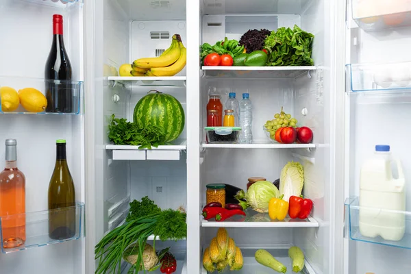 Nevera abierta llena de frutas, verduras y bebidas — Foto de Stock