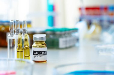 Laboratuvarın arka planına karşı enjeksiyon için küçük şişedeki aşı