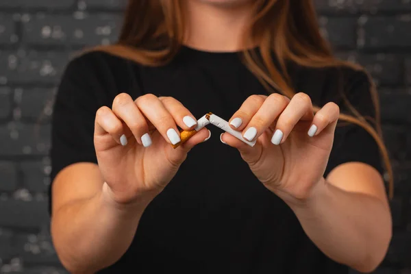 Unrecognizable woman breaking cigarette in her hands quitting habit — Stock Photo, Image