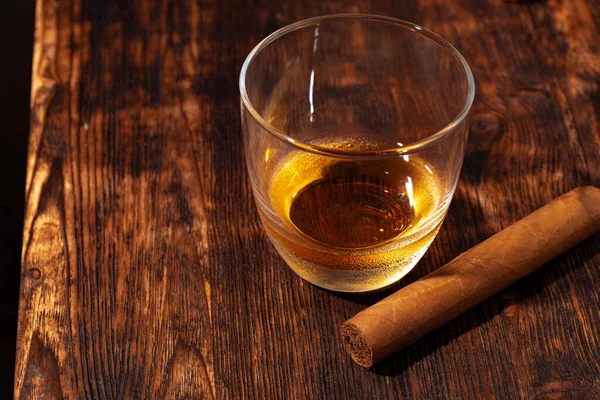 Ett glas whisky och cigarr på träbordet — Stockfoto