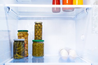 Buzdolabında cam kavanozlar dolusu konserve ürün var.