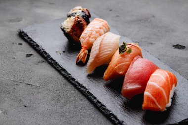 Gri arka planda servis edilen Nigiri suşisi seti