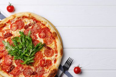 Biberli pizza beyaz ahşap masada.