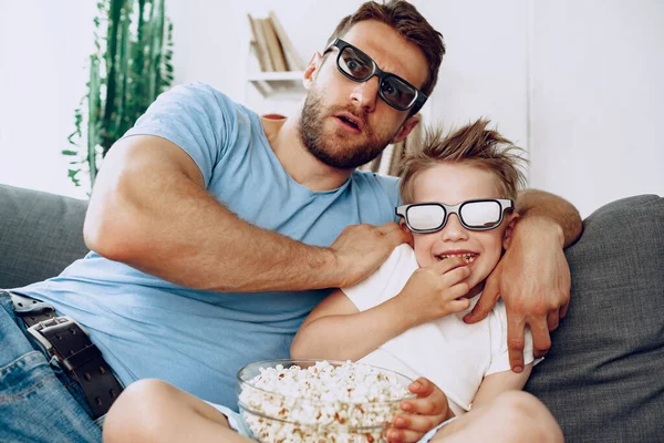 Padre e hijo viendo películas en casa en gafas 3D y comiendo palomitas de maíz — Foto de Stock