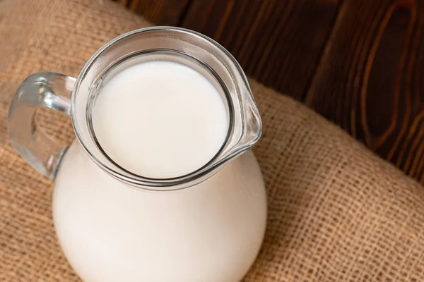 Glass jar of milk on old wooden table — Stock Photo, Image