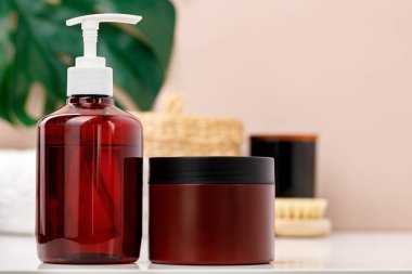 Kahverengi tenli konteynırlar banyoya yakın.