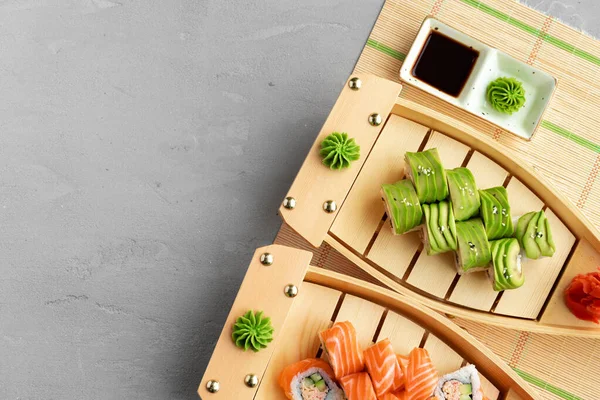 Avokádo sushi rolka s lososem podávaná na dřevěných talířích — Stock fotografie