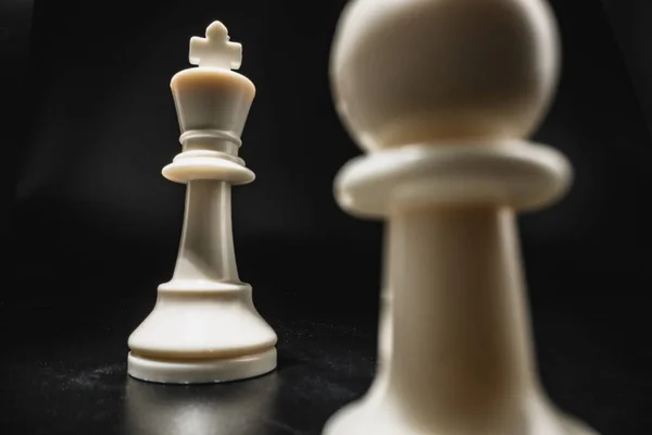 Gra w szachy z pionkami na czarnym tle — Zdjęcie stockowe