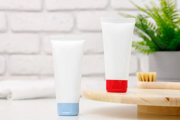 Tubos de productos para el cuidado de la piel blancos sobre fondo azul — Foto de Stock