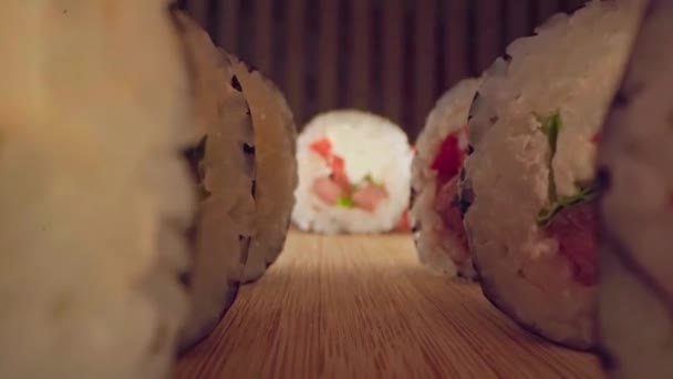 Zoom en diapositiva video de rollo de sushi japonés sobre fondo de madera — Vídeos de Stock