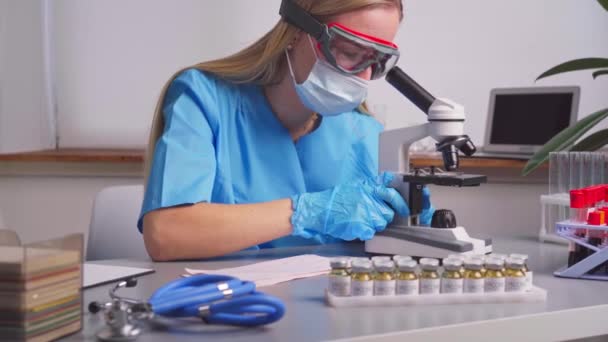 Travailleuse de laboratoire regardant au microscope — Video